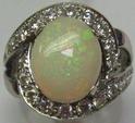 Bague tourbillon en or blanc ornée d'une opale de taille cabochon